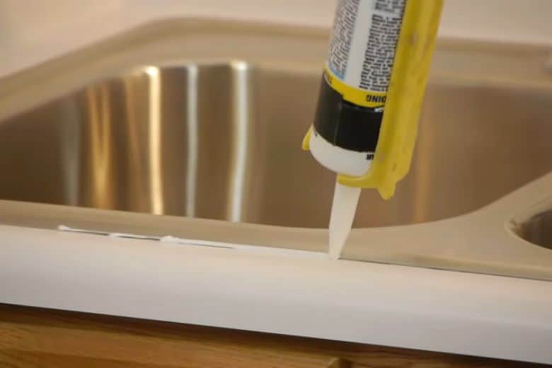 Use caulk to fill the gap between sink and countertop